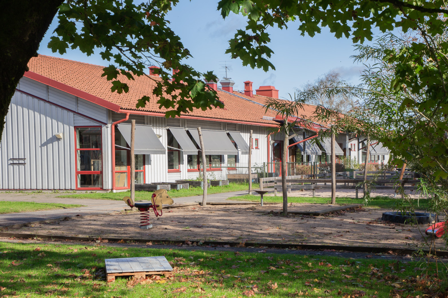Snickaregårdens förskola omgivet av lummig grönska en solig sommardag.