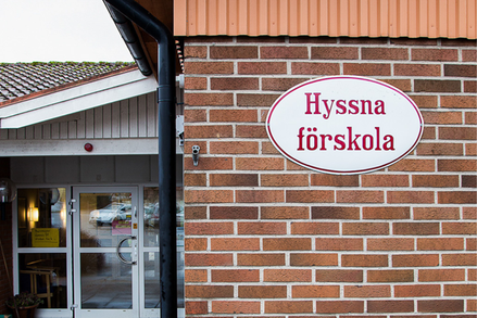 En fasadskylt på en tegelvägg med texten "Hyssna förskola".