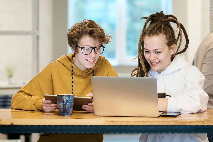 Två vuxna studenter tittar på en datorskärm.